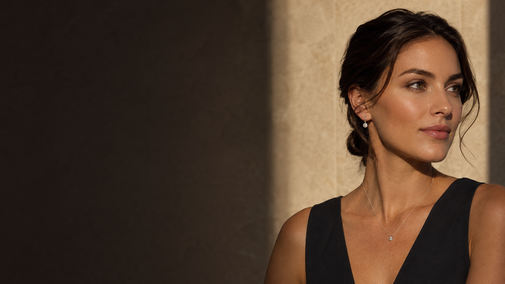 Woman wearing diamond earrings and a delicate necklace